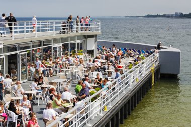 İskeledeki kafede kimliği belirsiz tatilciler