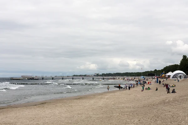 Varios turistas en la playa durante el día nublado — Foto de Stock
