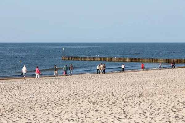 Varios turistas caminan a lo largo de la costa — Foto de Stock