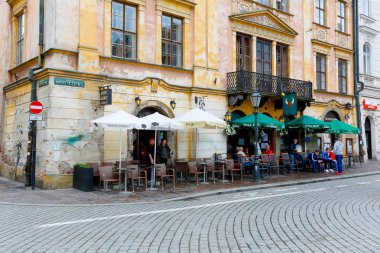 Açık bir Arnavut kaldırımlı sokakta restoranlarda oturma 