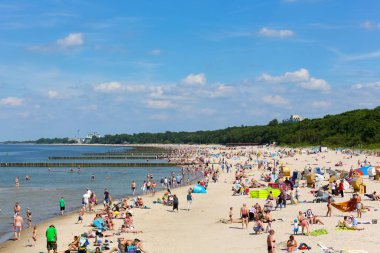 Kolobrzeg plajda güneşlenirken tatilcilerin