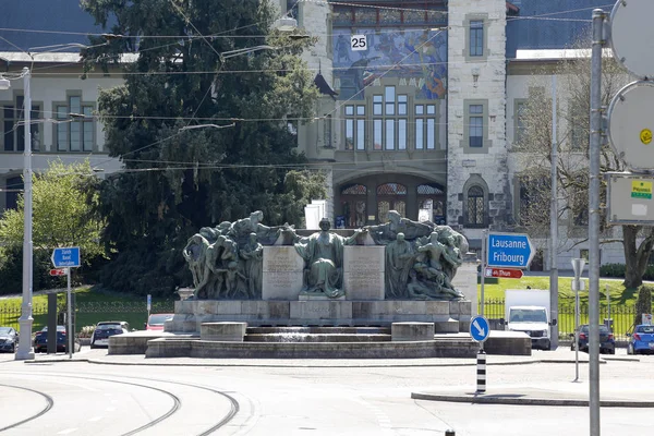 Massive monument on the background of the building — Stock Photo, Image