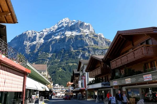 Aldea alpina y la enorme montaña rocosa —  Fotos de Stock