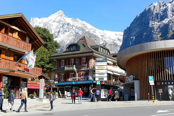 Mensen lopen naast de Alpine gebouwen — Stockfoto