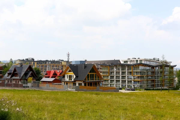 Large hotel building and modern residential houses — Stock Photo, Image