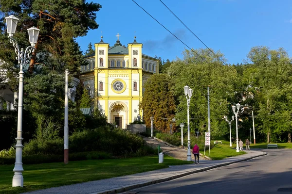 Kyrkan av gatan och gröna träd — Stockfoto