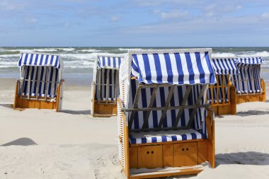 Deniz sahilinde birkaç gölgelikli plaj sandalyeleri