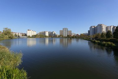 Park alanları ve gölü olan binalar.