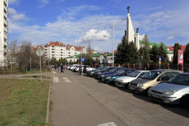 Varşova, Polonya - 01 Mart 2020 Goclaw konutlarındaki caddenin kenarına park edilmiş bir dizi araba. Burası büyük bir konutun parçası, kilise de burada..