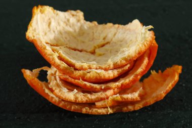 Koyu yeşil arka planda gösterilen portakal kabuğu.