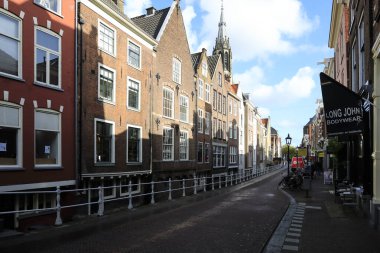 Delft, Hollanda - 10 Ekim 2019: Şık evlerin bulunduğu şehir caddesi. Bunlar eski binalar..