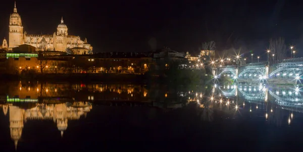 Uitzicht op de kathedraal van Salamanca tot uiting in de rivier op nig — Stockfoto