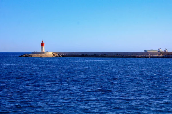 青い海に白い小さな灯台と赤い灯台があり — ストック写真