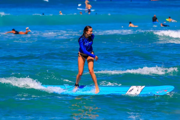 Young girl surfing standing up in Waikiki Beach Hawaii — Stock Photo, Image