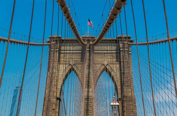 Close up view of the Brooklyn Bridge in New York, NY, one of the oldest suspension bridges in the United States with people on the bridge