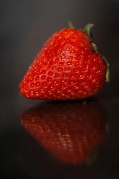 Red strawberries on black glossy background with reflection — Stock Photo, Image