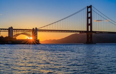 Yıldız patlaması etkisi ünlü Golden Gate Köprüsü tarafından gün batımında 
