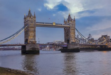 İngiltere 'de Thames nehri üzerindeki Tower Bridge ile günbatımında Londra şehrinin ufuk çizgisi manzarası