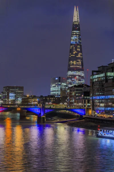 Skyline de Londres después de la puesta del sol con el fragmento y el puente Southwark a través del río Támesis con luces de noche — Foto de Stock