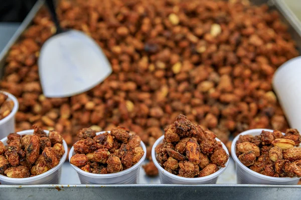 London street food - roasted caramelized peanuts in plastic cups on a cart on a bridge in London, England, UK — Stock Photo, Image