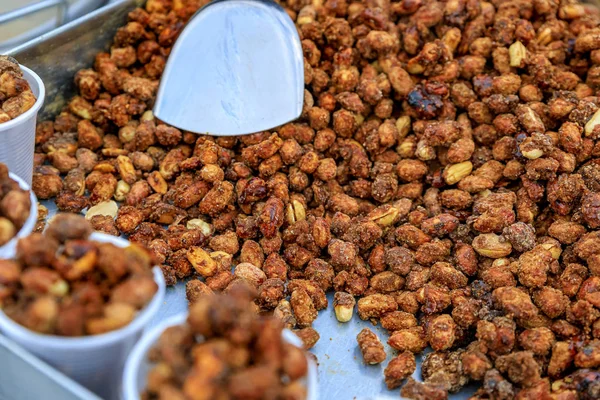 London street food - roasted caramelized peanuts in plastic cups on a cart on a bridge in London, England, UK — Stock Photo, Image