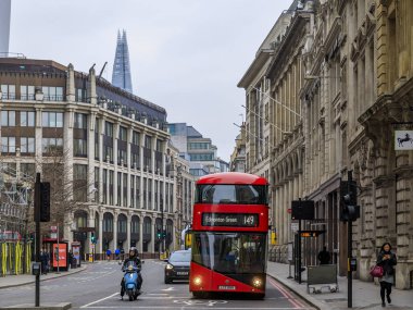 Londra 'nın merkezinde neredeyse boş bir caddede arka planda Çömlek ile ünlü kırmızı çift katlı Routemaster otobüsü.