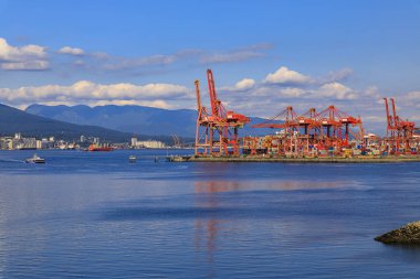 Vancouver limanı kırmızı kanat vinçleri ve kargo konteynırları ile Kanada 'nın limanındaki Centerm terminalinde