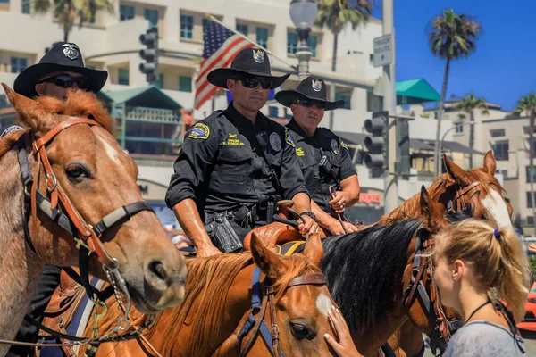 Oficiales de policía ecuestre de los departamentos de policía de Huntington Beach y Santa Ana frente al muelle de Huntington Beach — Foto de Stock