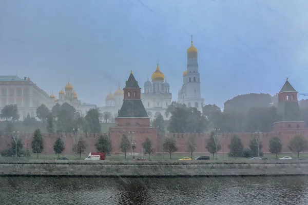 한 겨울 눈보라 속에 공중에 눈송이가 날리는, 모스크바의 크렘린 벽, 탑 및 대성당 의옥 상들 이 흐릿하게 보였다 — 스톡 사진
