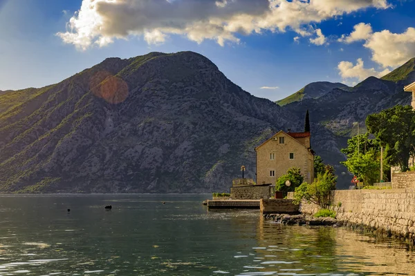 Altes steinhaus in kotor bucht mit bergen und kristallklarem wasser auf dem balkan, montenegro am adriatischen meer — Stockfoto