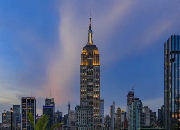 Небо Манхэттена с подсветкой Эмпайр-стейт-билдинг и небоскребами на закате, Нью-Йорк, США — стоковое фото