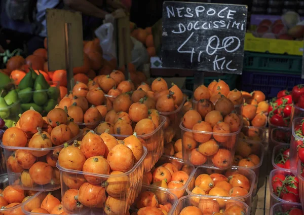 Fresh loquat medlar fruit at local outdoor farmers market with a sign advertising it for 4 EUR a kilo, Ventimiglia Italy — Stockfoto