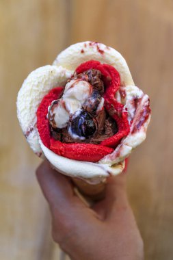 Amarena, çikolata ve çilek aromalı gül şekilli dondurma. Nice, Fransa 'da bir şeker konisinde kirazlı.