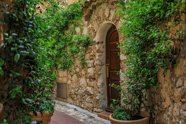 Stone exterior of old buildings on narrow streets in the picturesque medieval city of Eze Village in the South of France, along the Mediterranean Sea