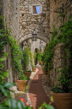 Stone exterior of old buildings on narrow streets in the picturesque medieval city of Eze Village in the South of France, along the Mediterranean Sea clipart