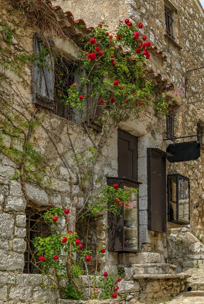 地中海沿いのフランス南部の絵のような中世都市 エズ村の通りに花を持つ古い建物の石造りの外観 — ストック写真
