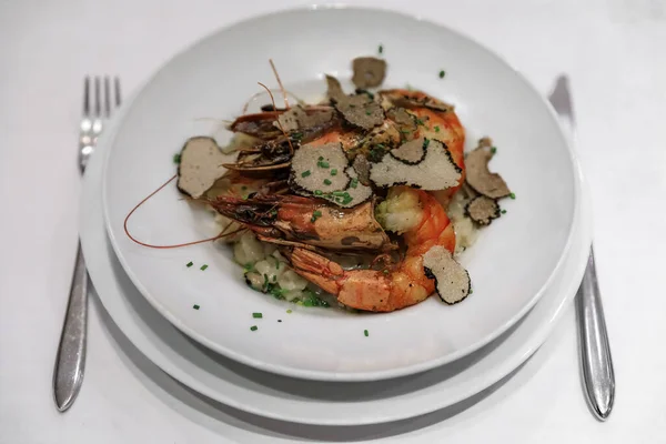 在法国尼斯的一家豪华餐馆里 在盘子里切好的黑松露片和烤虾一起食用 — 图库照片