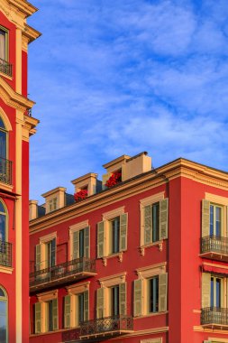 Place Massena 'daki geleneksel Akdeniz evlerinin günbatımı manzarası, Fransa' nın güneyindeki Nice 'li Vielle Ville kasabasının ticari ve kültürel simgesi.