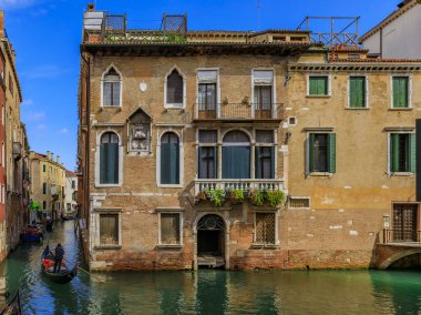 Gondol Venedik İtalya 'da bir kanalda binalardan geçiyor.