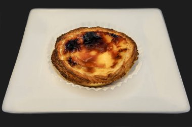 Pasteis de nata, Portekiz 'in Porto şehrinde beyaz bir tabakta yumurta, tarçın, şeker ve un ile yapılan geleneksel Portekiz kremalı tart tatlısı.