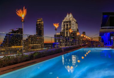 Austin, Teksas ABD - 27 Ocak 2020: Tiki meşaleleri bir çatı havuzu ve şehir merkezi Skyline ile Westin Hotel 'den gün batımında Frost Bank Tower ile