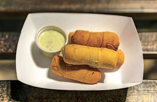 Top view of a paper plate with tequenos, popular Venezuela fried bread cheese sticks stuffed with queso blanco, from a food truck in Austin, Texas USA