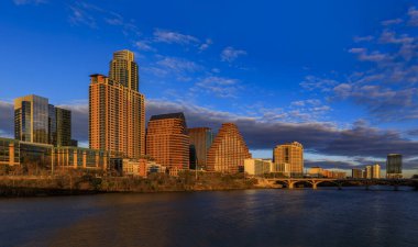 Şehir merkezindeki gökdelenli panorama günbatımını yansıtıyor. Lady Bird Lake ya da Texas, Austin 'deki Colorado Nehri üzerindeki Town Lake' de altın saat ışığı görülüyor.