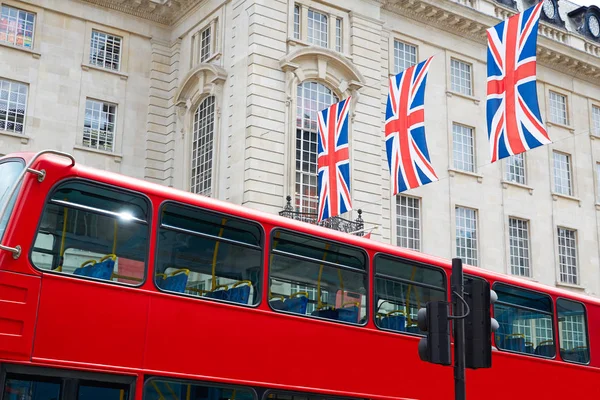 London buss och brittiska flaggor i Piccadilly Circus — Stockfoto