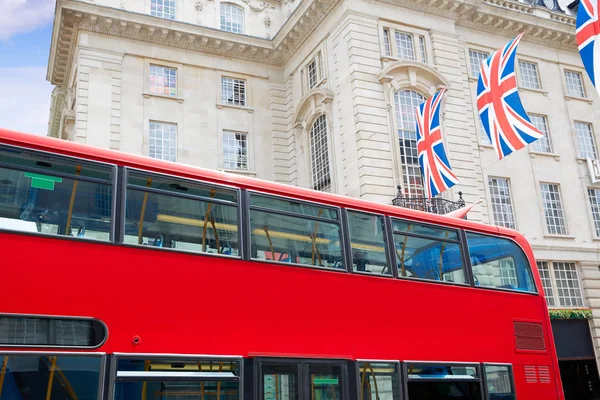 London buss och brittiska flaggor i Piccadilly Circus — Stockfoto