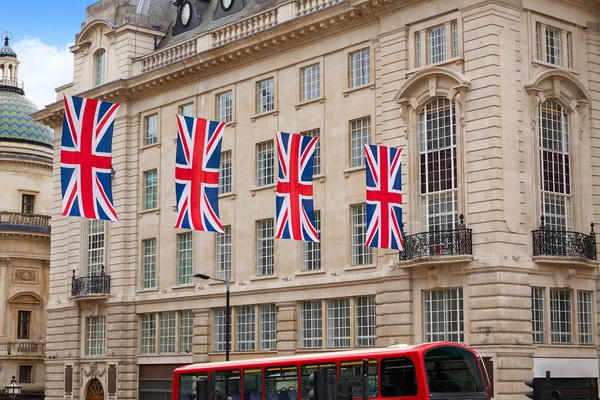 London buss och brittiska flaggor i Piccadilly Circus — Stockfoto