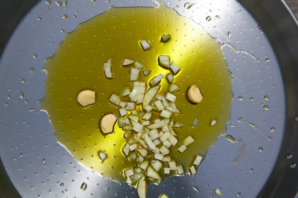 Paella z Hiszpanii przepis pierwszy krok podsmażyć cebulę i czosnek — Zdjęcie stockowe
