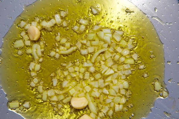 Paella aus Spanien Rezept erster Schritt Zwiebeln und Knoblauch braten — Stockfoto
