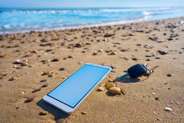 Telefone celular e chaves do carro na areia da praia — Fotografia de Stock