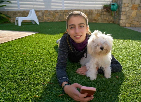 Adolescente chica con teléfono móvil y perrito — Foto de Stock